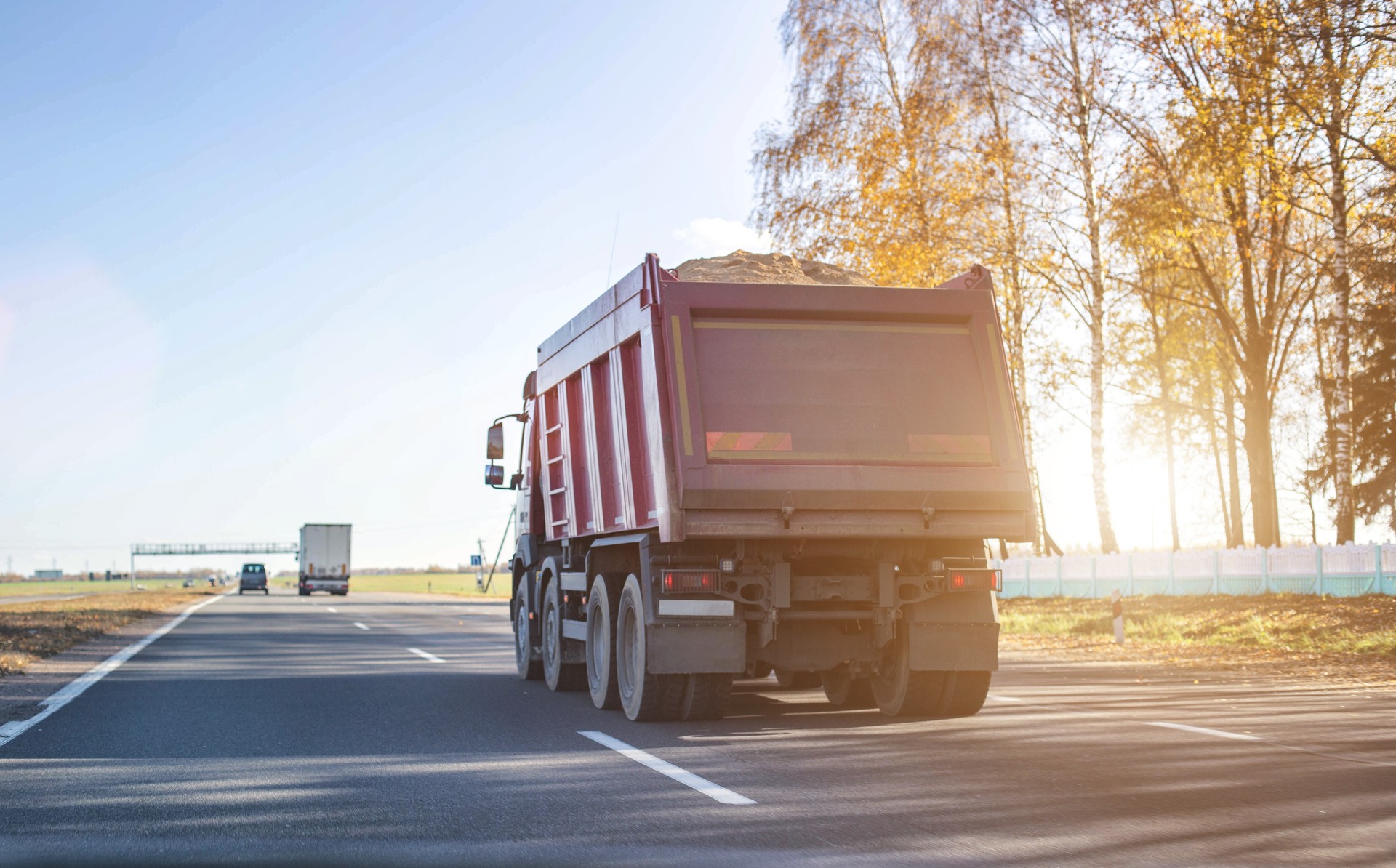 A 40 ton truck carries construction sand on the highway. Concept of overload on the roads and rental of a dump truck for work, copy space